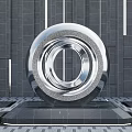 Modern Metallic Spherical Sculpture With Circular Ring Design On Stone Floor Against Gray Wall