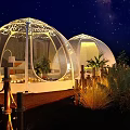 Garden Landscape with Transparent Dome Tents Starry Sky Lighting Wooden Deck and Grass at Night