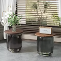 Two Modern Side Tables With Wooden Tops And Dark Bases Near Potted Plants And Blinds