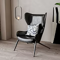 Black Leather Accent Chair with Blue White Patterned Pillow Hanging Lantern Green Plant Abstract Painting