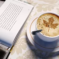 Coffee Cup With Maple Leaf Latte Art Next To Open Book On Floral Tablecloth
