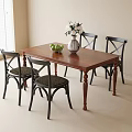Wooden Dining Table With Four Black Chairs And Fruits In Vase With White Flowers