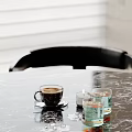Modern Decorative Ornament Set with Coffee Cup Lit Candle and Glassware on Black Marble Tabletop