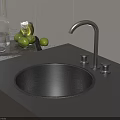 Black Round Kitchen Sink With Silver Faucet Two Handles And Green Fruits On Countertop