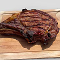 Perfectly Grilled Juicy Steak On Wooden Cutting Board With Charred Edges