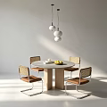 Minimalist Round Dining Table with Four Woven Chairs Brown Seats and Three White Pendant Lights