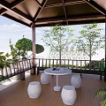 Garden Pavilion With Brown Roof Wooden Floor Columns Railing And Surrounding Green Plants
