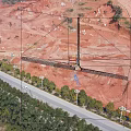 Aerial View Industrial Factory Building With Surrounding Roads Vehicles Red Soil Hills And Distant Mountains