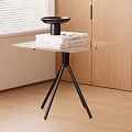Modern Glass Top Side Table with Black Tripod Legs by Wooden Cabinet and Blinds