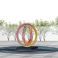 Colorful Circular Sculpture with Red Pink Blue Rings in Water with Reflection and Tree Background