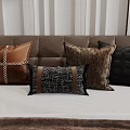Brown and Black Decorative Pillows with Leather and Woven Textures on Bedroom Bed