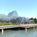 Modern Wavy Glass Structure Waterfront Boardwalk With Green Trees And Visitors