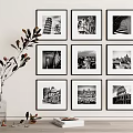 Nine Framed Black And White Architectural Photos On Wall With Vase Plant And Book