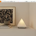 Modern Triangle Table Lamp on White Shelf with Stacked Books and Framed Decorative Painting
