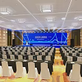 Professional Conference Hall Setup With Blue Backdrop Stage Podium And Seating Arrangement