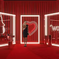 Woman In Black Dress At Women's Day Setup With Red Curtains Neon Heart Decorations