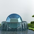 Garden Ornament Glass Sphere Fountain With Flowing Water Surrounded By Green Plants And Lily Pads