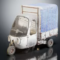 Vintage Three Wheeler Tricycle With Blue Tarpaulin Covered Cargo Bed And Weathered Metal Body