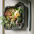 Art Installation Featuring Black Stone Container With Green Plants And Colorful Flowers
