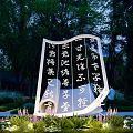 Open Book Shaped Sculpture With Chinese Calligraphy Characters Outdoor Park Courtyard Night Lighting Green Plants