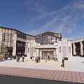 Modern Commercial Street With Classical Columns Large Windows And Pedestrians Walking