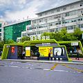 Youth Palace Station Green Shelter With Trees Pedestrians And Surrounding Buildings