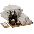 Bathroom Accessories With Gray Bath Towels Rolled Towels Dark Bottles Candles Soap On Wooden Tray