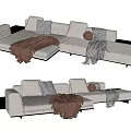Modern Light Colored Sectional Sofa With Throw Pillows And Knitted Blanket