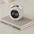 White Alarm Clock With Bells Digital Display Showing Time On Gray Box With CELINE
