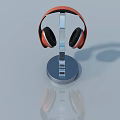 Orange Over Ear Headphones Placed On Chrome Metal Stand With Reflective Surface