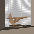 Elegant Metallic Streamlined Sculpture Artwork With Circular Base By Window Blinds