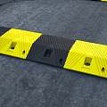Road Infrastructure Featuring Yellow Black Speed Bumps and Asphalt Traffic Lines