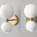 Modern Wall Sconces With White Globe Shades And Brass Bases On Gray Wall