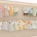 Cute Baby Clothes In Pastel Colors Hanging On Double Racks With Various Styles