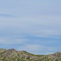Symmetrical Mountain Landscape Featuring Green Meadows Lush Vegetation And Rolling Terrain