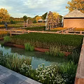 Scenic Countryside Landscape Featuring Golden Fields Autumn Trees Wooden Bridge Watermill and Cottage