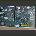 Graffiti Covered Green Cube With Colorful Stickers On Wooden Base