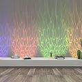 Decorative Lights With Colorful Flowing Line Projections On Wall And Small Ornaments Cacti Below