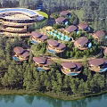 Unique Lakeside Homestay Buildings With Circular Roofs Surrounded By Lush Forests And Scenic Landscapes