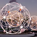 Illuminated Spherical Wireframe Sculptures With Palm Trees In Outdoor Twilight Sky