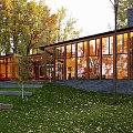 Detached Villa Surrounded By Autumn Green Trees With Lawn Large Glass Windows And Stone Wall