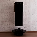 Black Cylindrical Fireplace with Round Base on Wooden Floor against Patterned Wall Modern Design