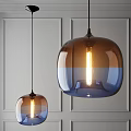 Modern Glass Pendant Lights in Brown and Blue Lit Against Gray Wall with Warm Glow