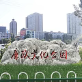 Rockery Stone with Cultural Park Inscription in Urban Green Space and Buildings