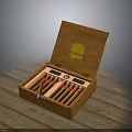 Open Wooden Cigar Box With Gold Emblem Containing Cigars On Wooden Surface