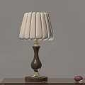 Table Lamp With White Lampshade Wooden Base Golden Accents And Red Decorative Items On Table