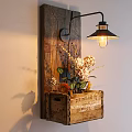Rustic Wall Lamp with Black Metal Arm on Wooden Plank and Flower Filled Crate