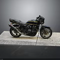 Black and Yellow Striped Motorcycle Parked on Gray Mat with Dark Background