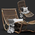 Comfortable Rattan Lounge Chair With Gray And White Pillows And Plaid Blanket