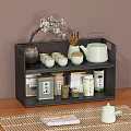 Two Tier Black Metal Shelf Holding Tea Set Teacups Teapot Tea Canisters on Wooden Table